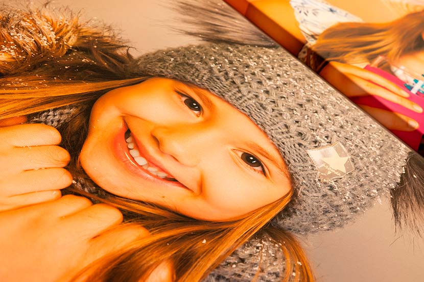Detail fotoplátna smějící se slečny v zimní čepici